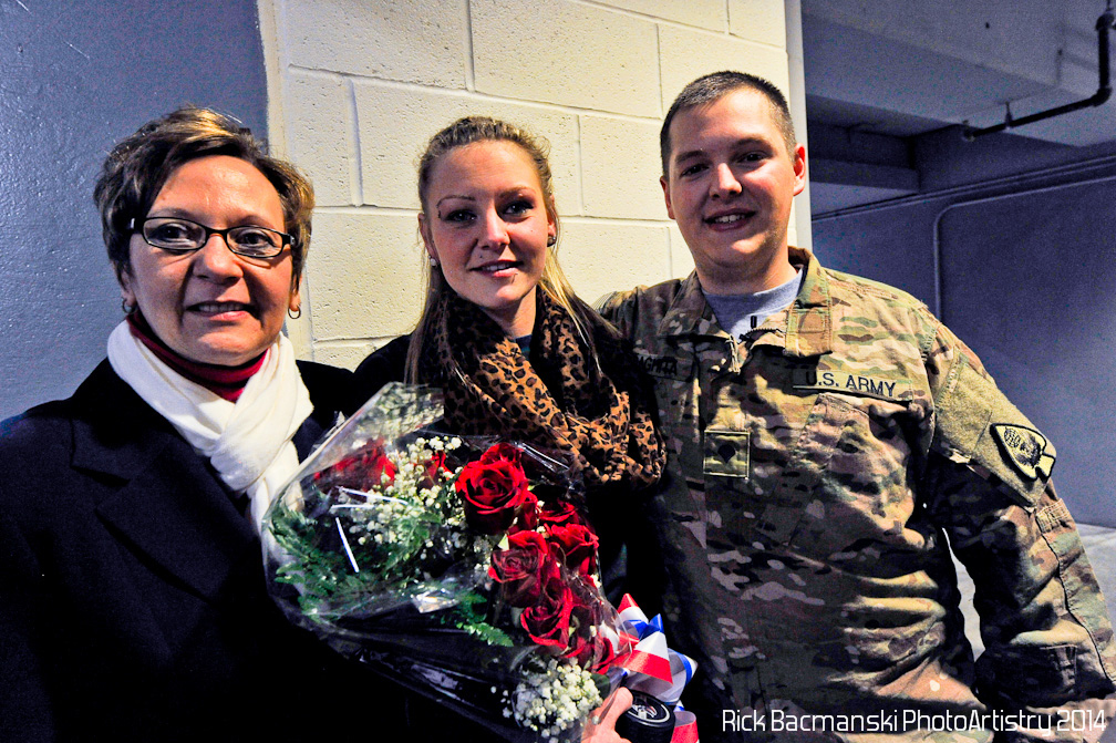 Ziff Law's Annette Viselli Thorne, left, joins Army Spc. Albert "Joey" Daghita and his wife Brittany after the Veterans of the Game surprise Saturday at First Arena.